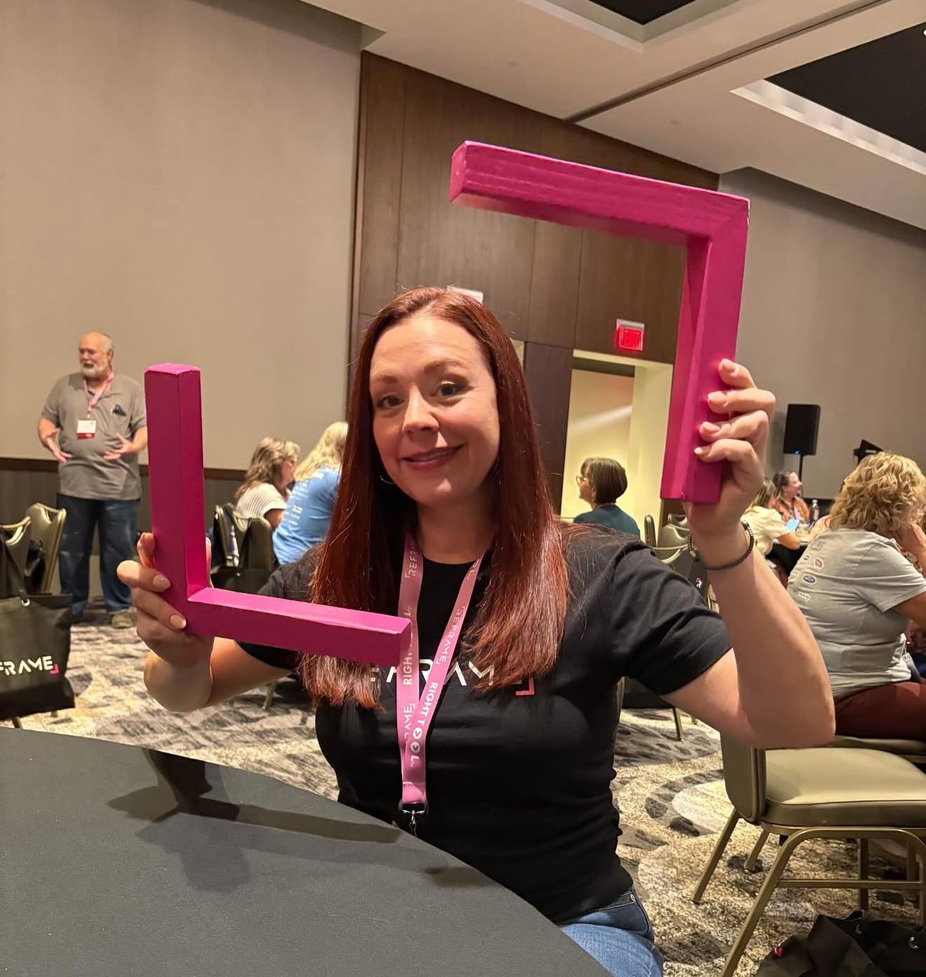 Amanda holding a ReFrame frame at the ReFrame conference