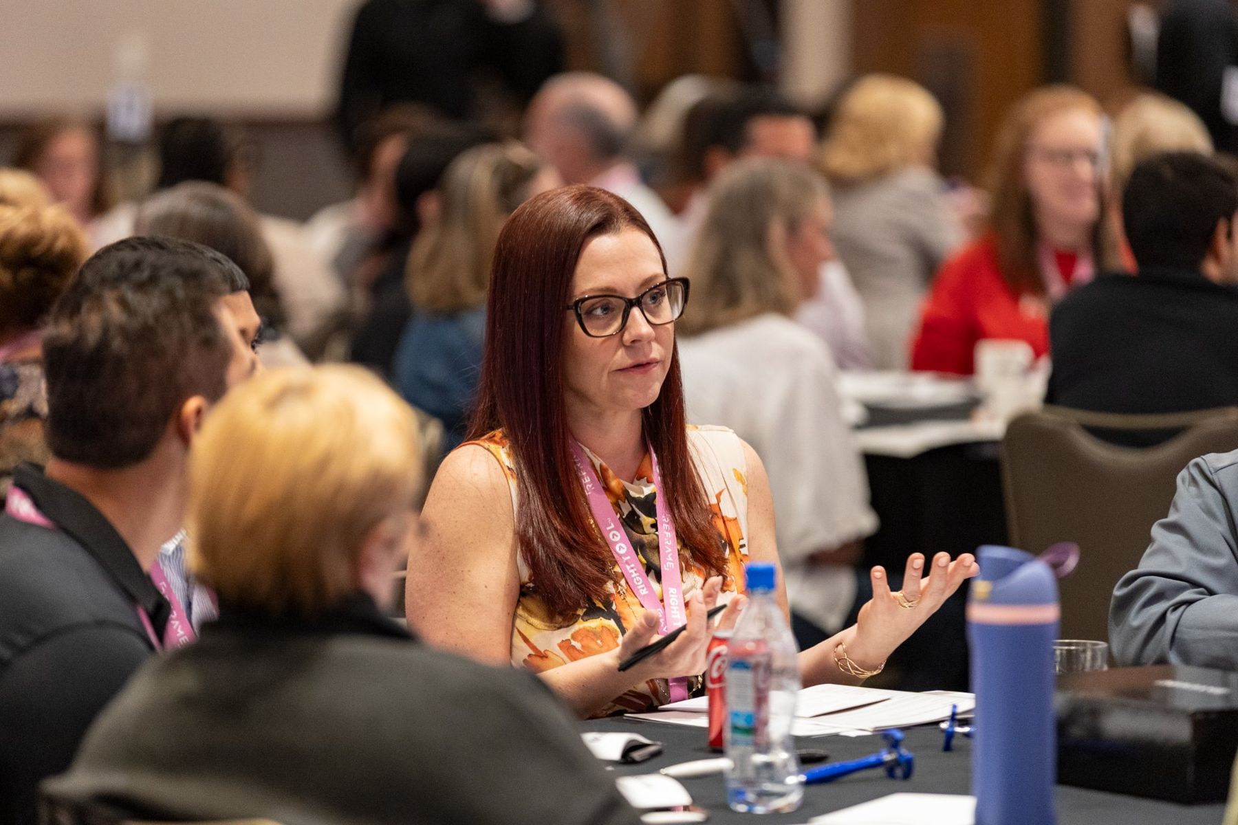 Amanda in conversation at a crowded conference table